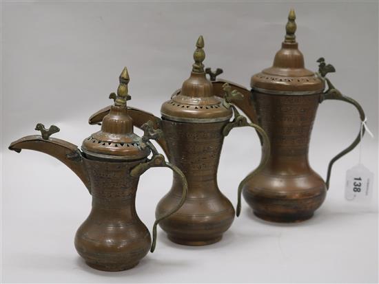 A set of three Bahrain brass and copper dallah coffee pots with old receipt from 1984 largest 28cm